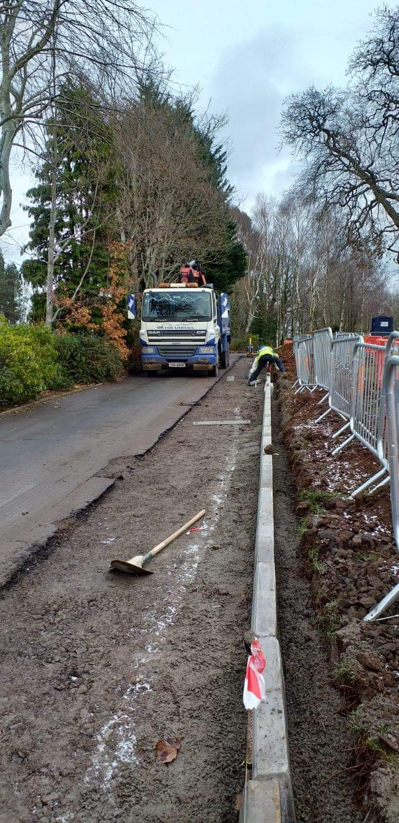 Kerbing and edging being laid along a rural roadside.