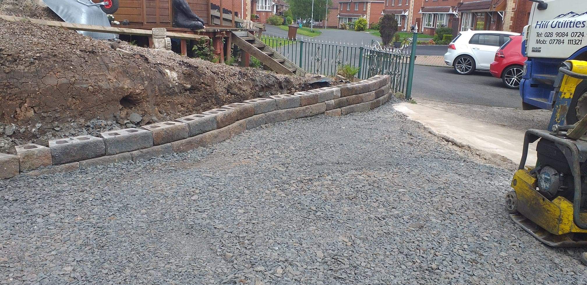 Compacting the sub-base on a new driveway, with kerb edging laid.
