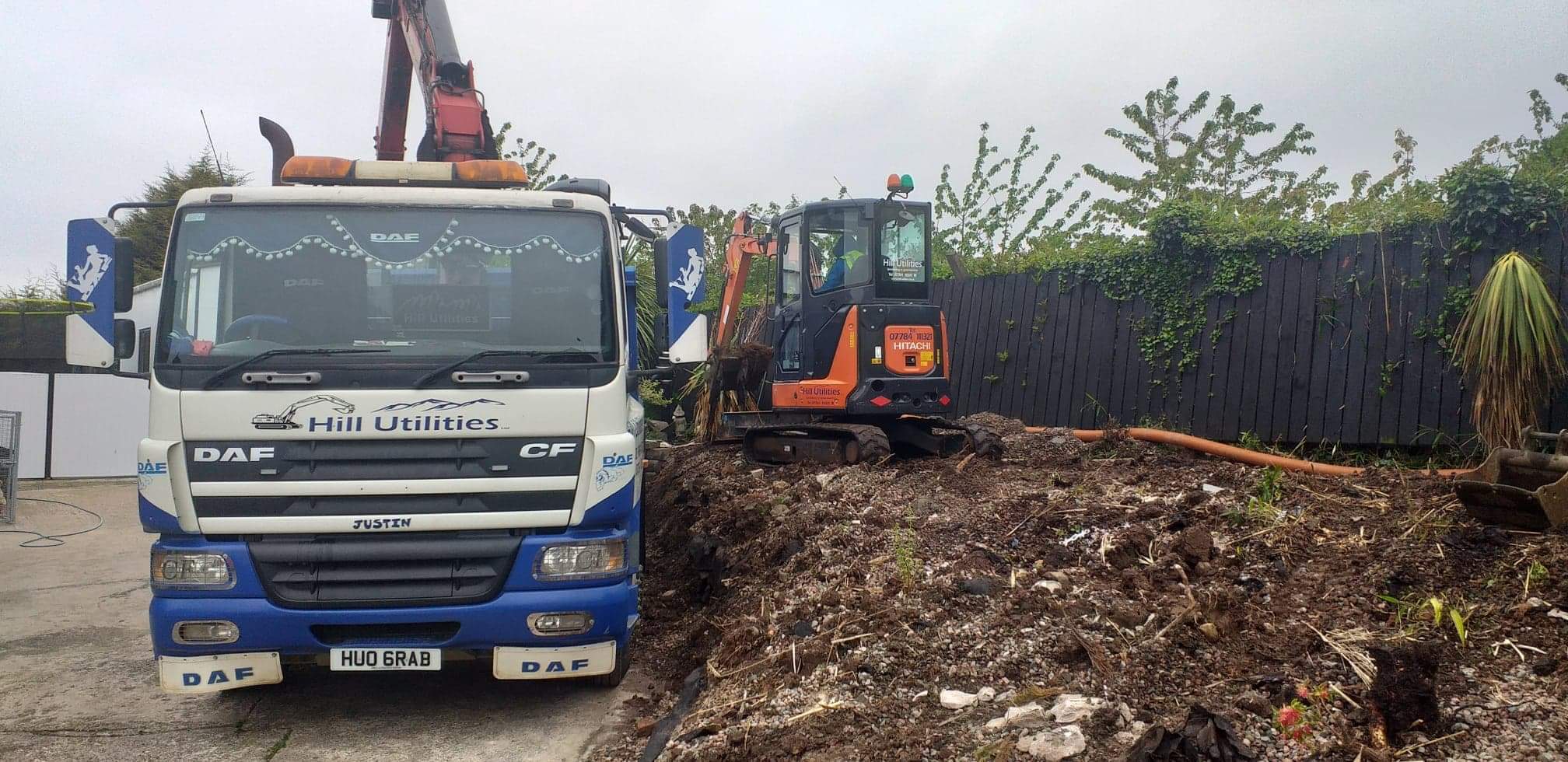 Site clearance in a domestic garden with lorry and excavator.