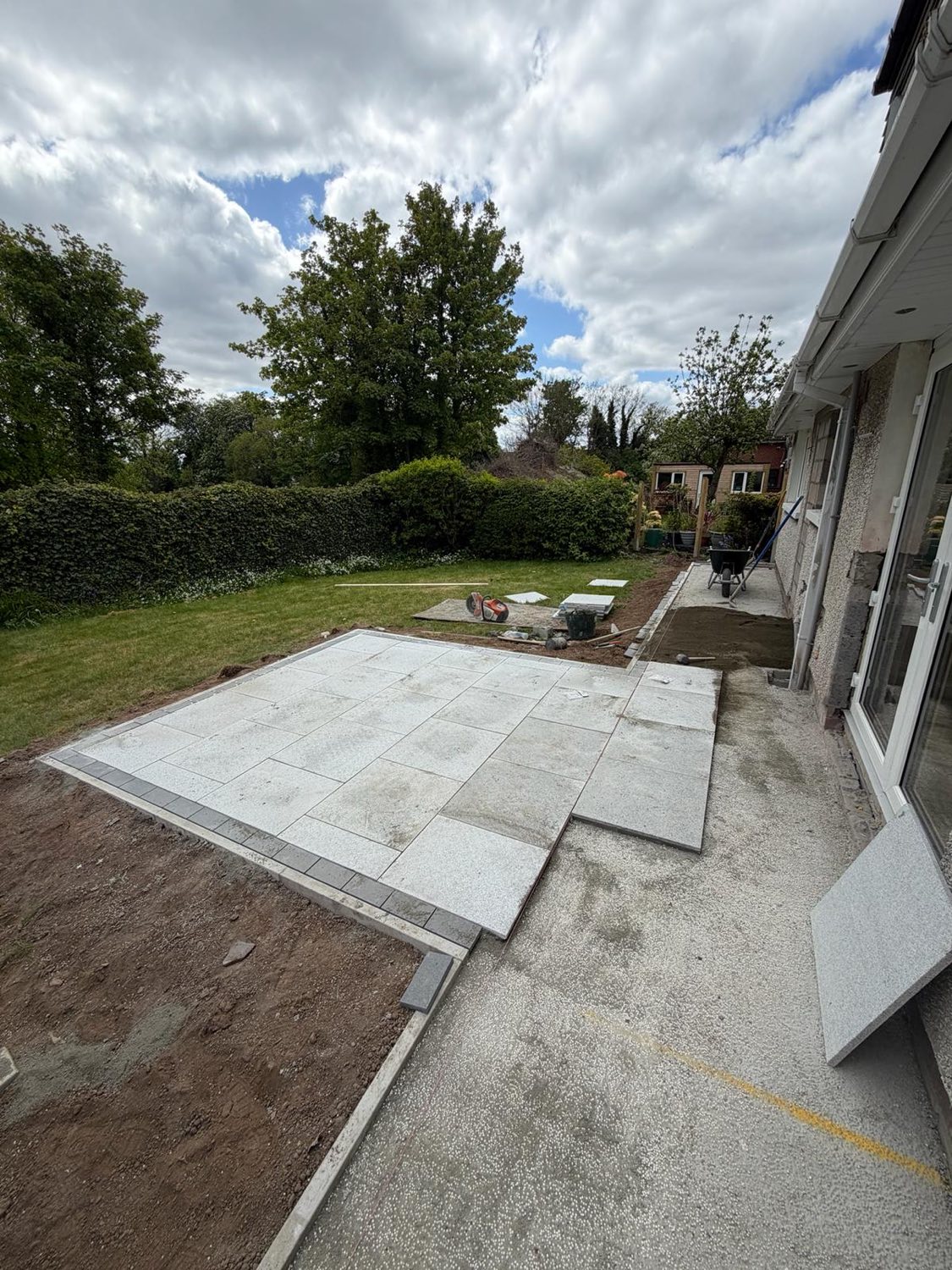 A large porcelain-paved patio opening onto the rear garden.