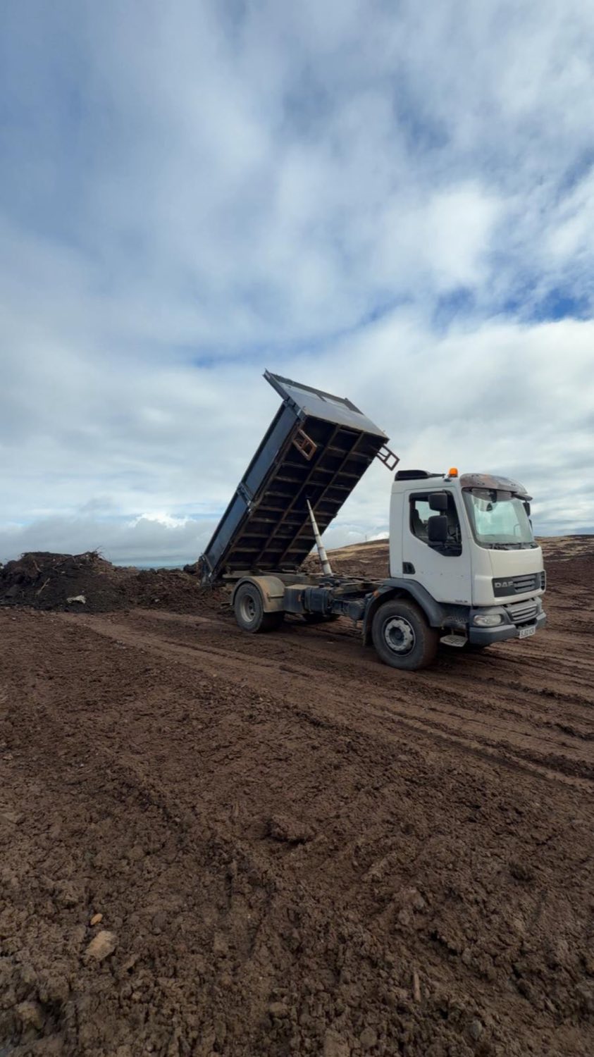 A tipper lorry discharging material during bulk earthworks.