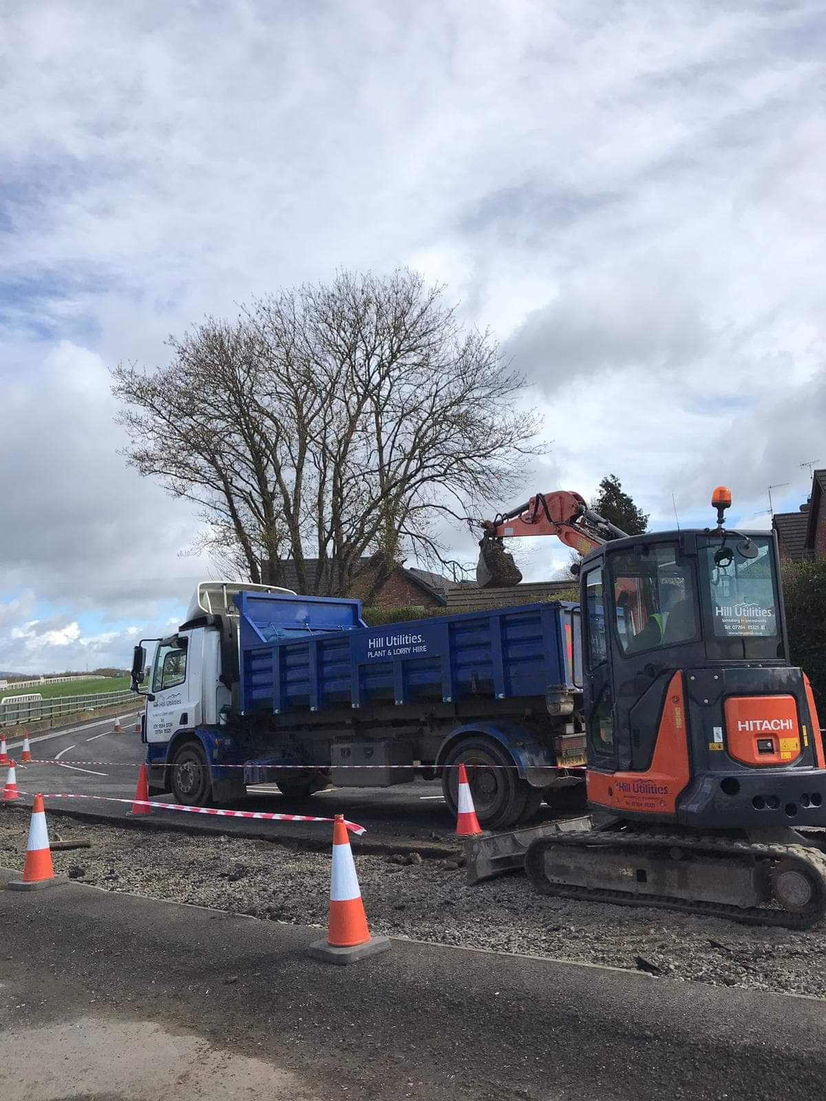 Hill Utilities tipper lorry and tracked excavator set up for a roadside job.