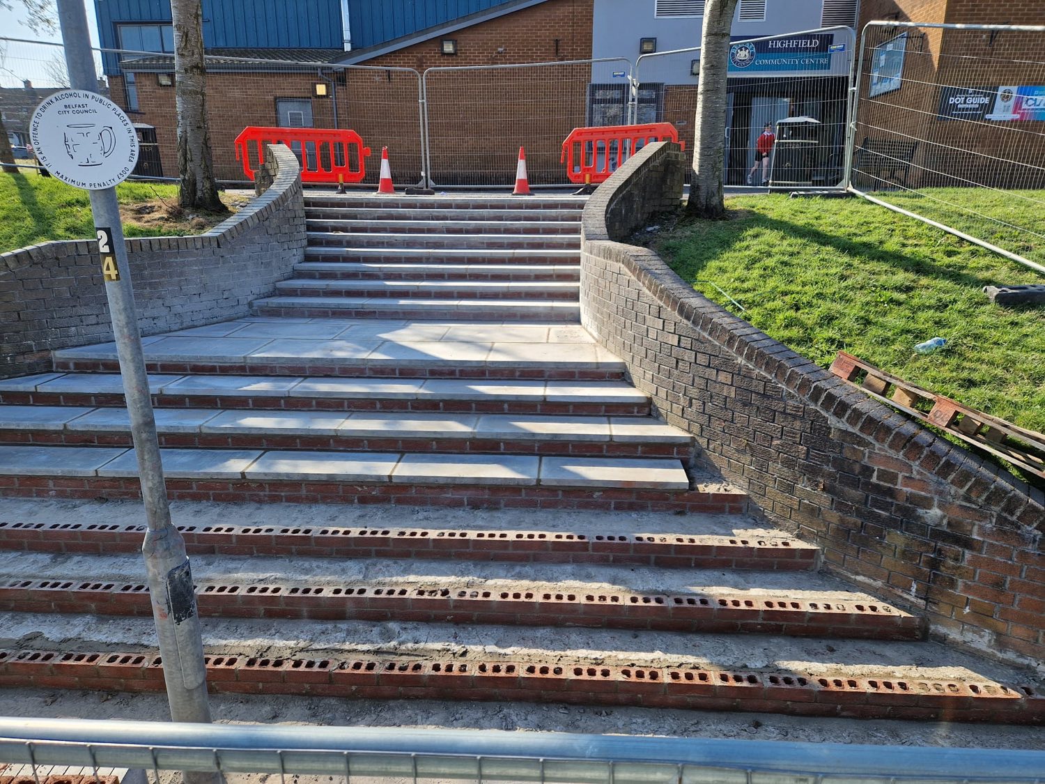 New brick-faced steps and retaining walls under construction.