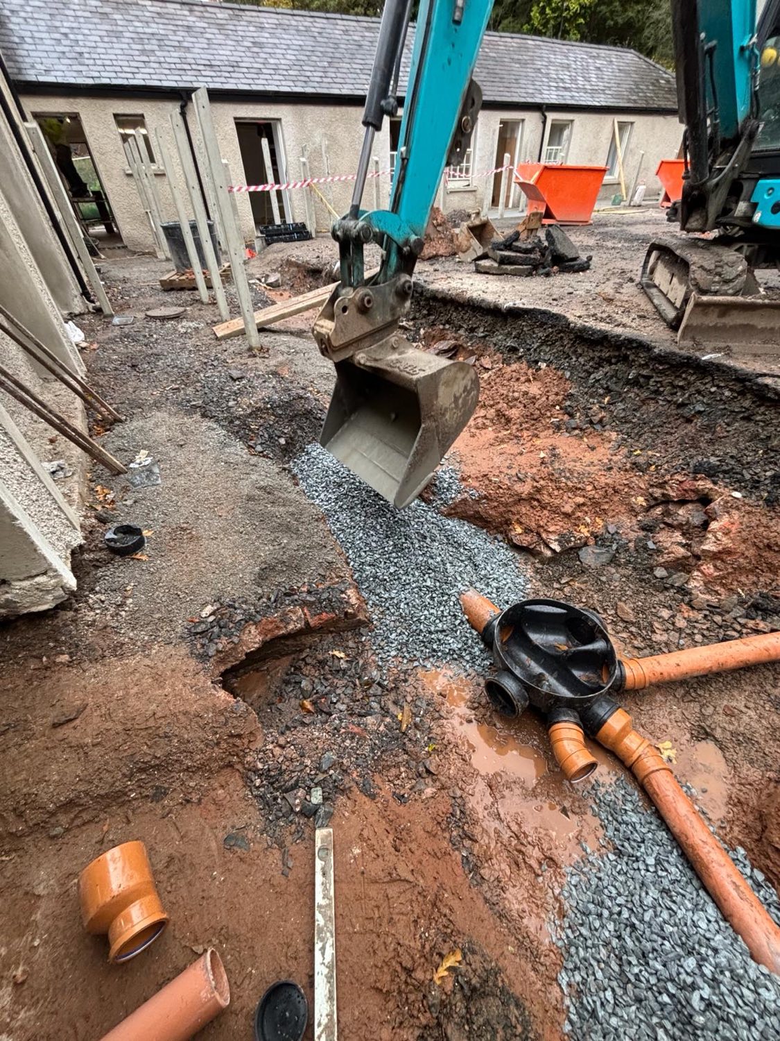 Laying new underground drainage and a junction chamber in free-draining stone.