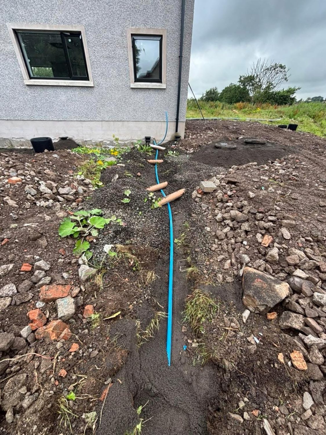A new blue MDPE water supply pipe laid in a trench to a property.