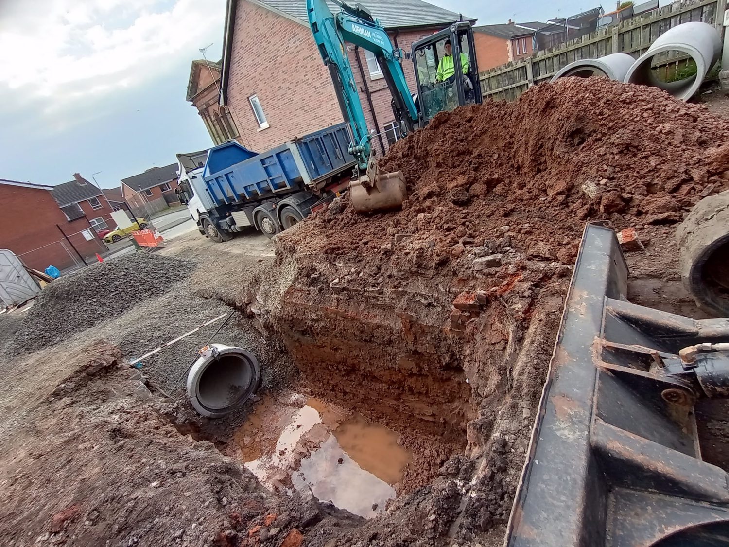 A deep excavation for a new drainage connection on a housing site.