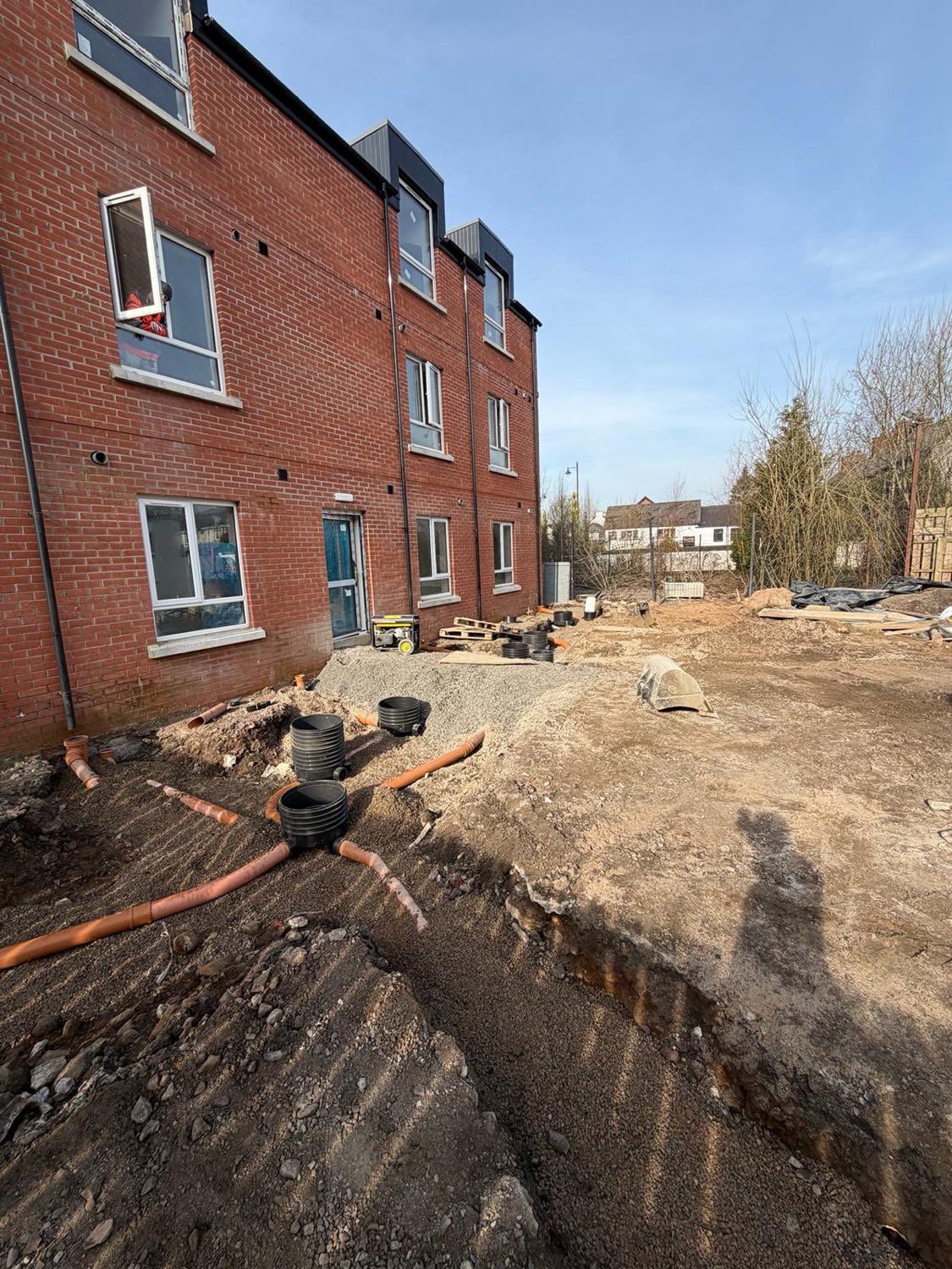 Drainage and service runs installed behind a new apartment block.