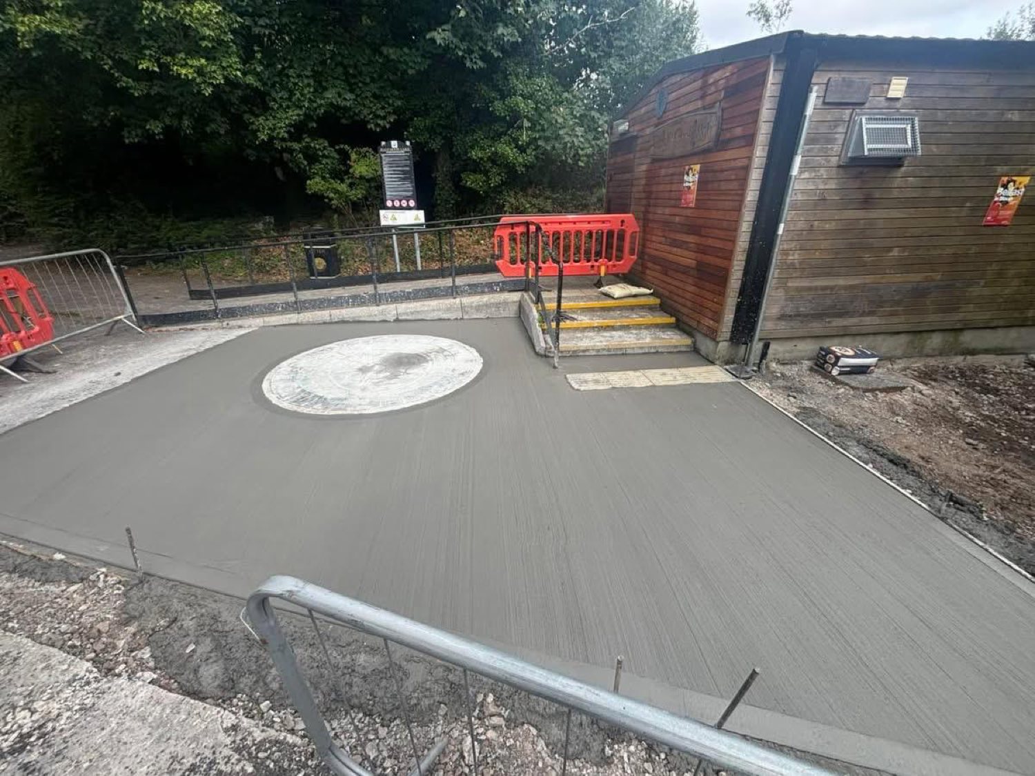 A newly poured concrete hardstanding beside the park building.