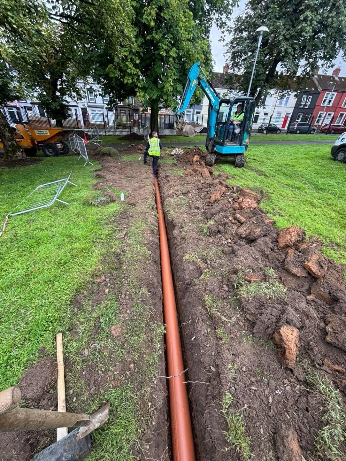 Laying a new drainage pipe run across a public park.
